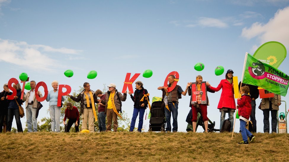 Активисты держат письма "Stop Kohle" (Стоп уголь) против расширения угольного разреза возле Гросс-Гастрозе, Германия. 23 августа 2014 г.