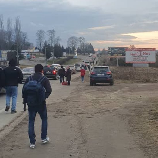 A queue of cars and people walking in an area close to the Polish border in Ukraine