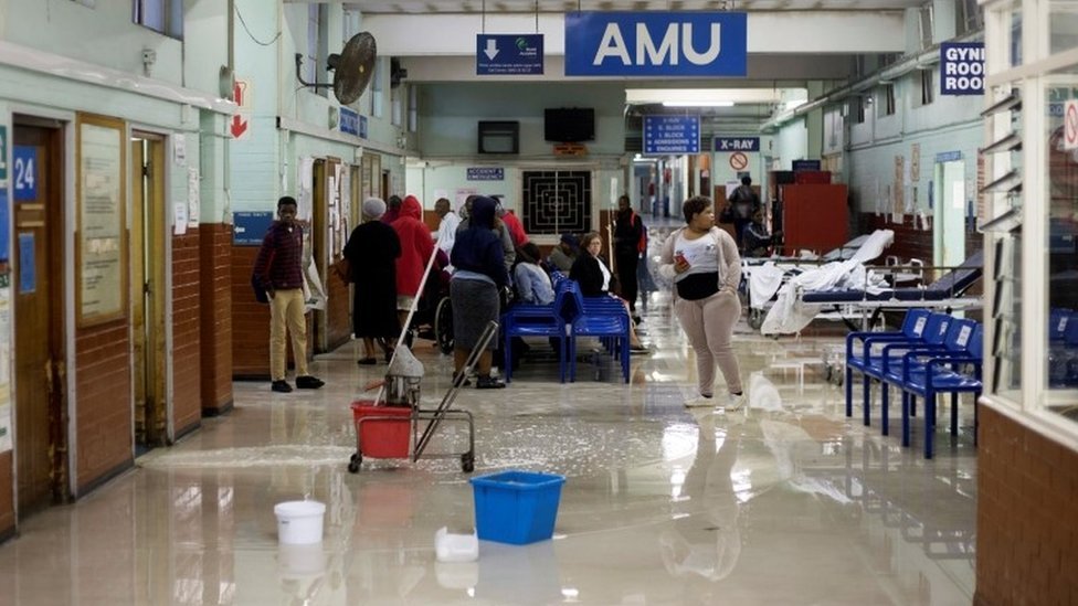 Уборщики вытирают воду в больнице короля Эдуарда VIII во время шторма в Дурбане, Южная Африка, 10 октября 2017 г.