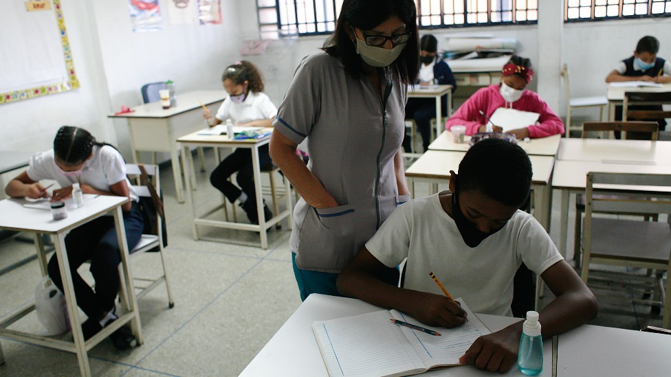Maestra supervisando alumnos en una escuela en Venezuela