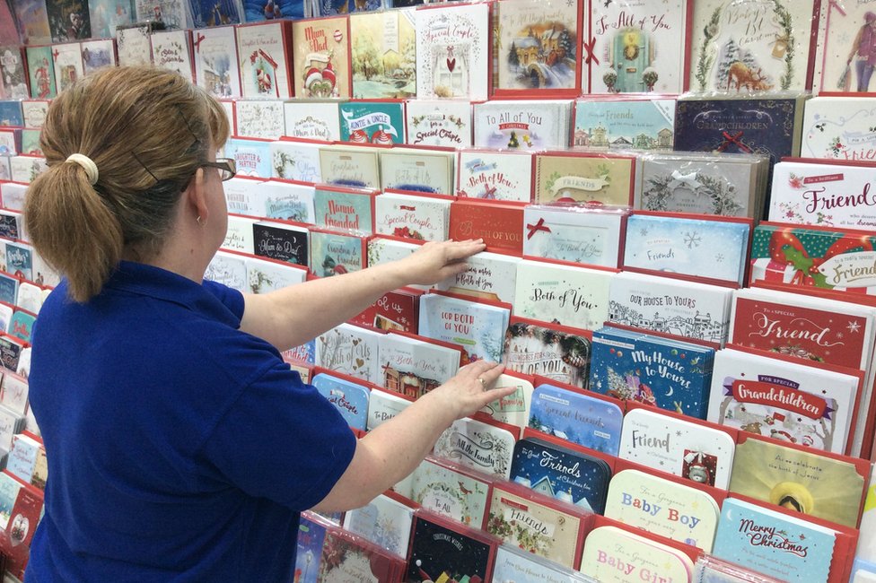 Менеджер магазина сортирует рождественские открытки в Card Factory