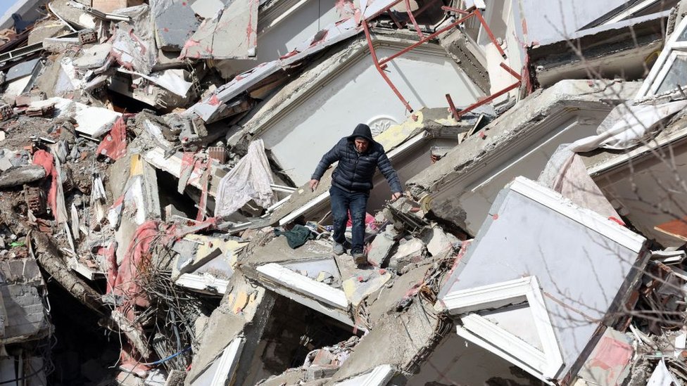 Un hombre camina entre los escombros de un edificio derrumbado en Kahramanmarash el día después de que un terremoto de 7,8 grados de magnitud azotara el sureste de Turquía.