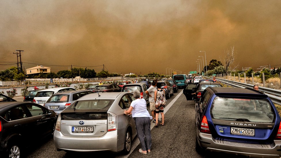 Автомобили заблокированы на закрытой национальной дороге во время лесного пожара в Кинете, недалеко от Афин