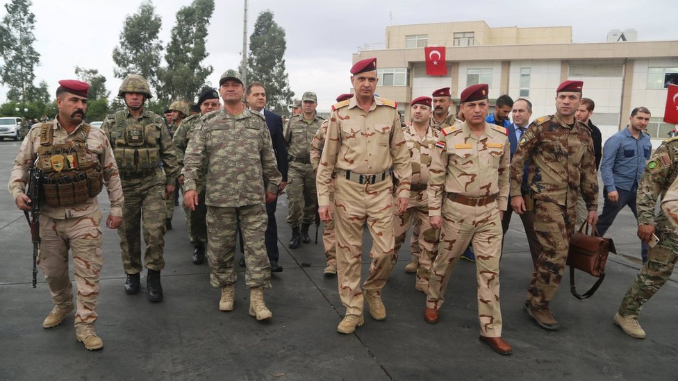 Командующий турецкой армией Исмаил Метин Темель (3-й слева) идет с начальником штаба Ирака генералом Османом аль-Ганми (в центре) во время встречи с турецкими и иракскими солдатами у пограничных ворот Хабур, Турция (31 октября 2017 г.)