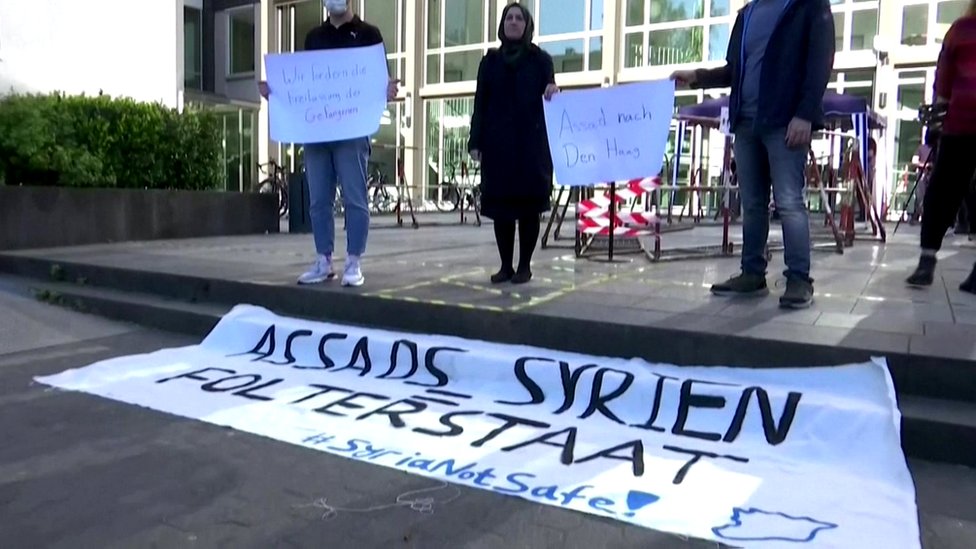 Активисты держат плакат у здания суда в Кобленце