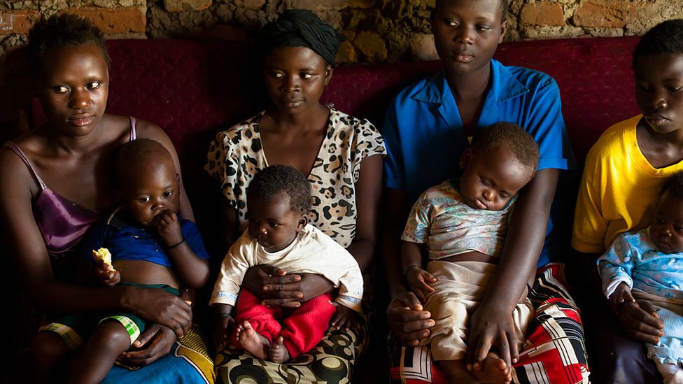 Mujeres africanas con sus hijos en brazos.