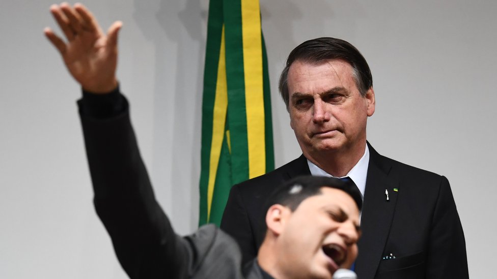 Jair Bolsonaro escucha orar a un pastor evangélico.