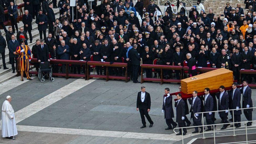 Pallbearers carry the coffin of Pope Emeritus Benedict XVI before Pope Pope Francis (L) for him to pay his respects at the end of his funeral mass at St. Peter's square in the Vatican on January 5, 2023