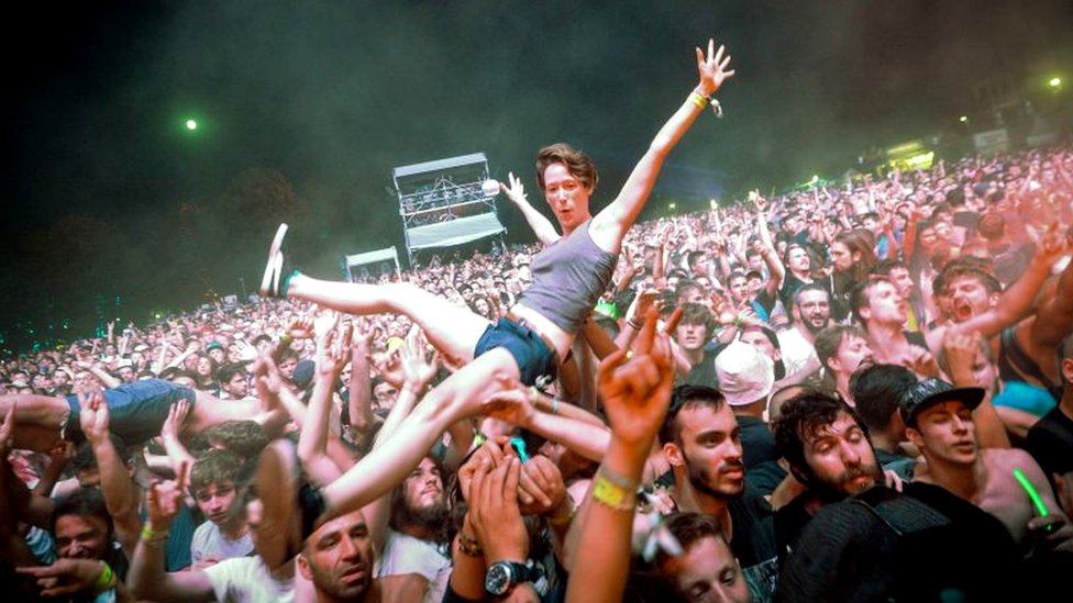 A fan crowd-surfs at a rock concert