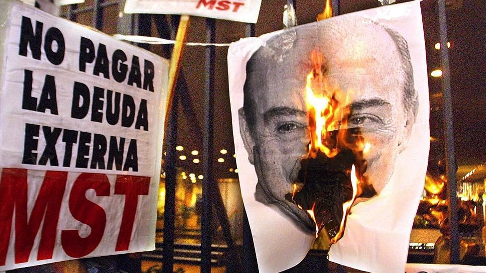 Pemrotes membakar foto Presiden Argentina De la Rua dalam aksi pada Desember 2021