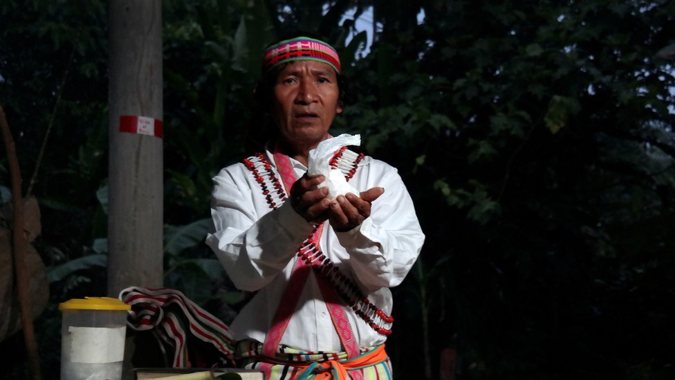 Шайнкиам Ямпик Вананч, диакон, рукоположенный католической церковью, поддерживает хозяина во время литургии с коренными народами ачуар в часовне в Виджинте, деревне в перуанской Амазонии, Перу, 20 августа 2019 года.