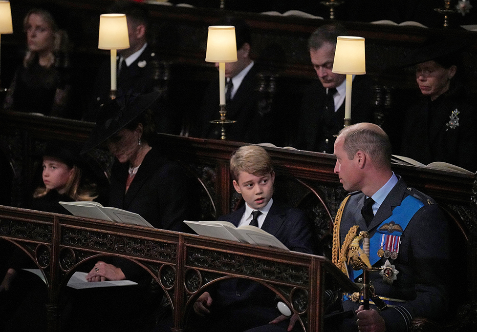 (front row, left to right) Princess Charlotte, the Princess of Wales, Prince George, and the Prince of Wales, watch as the Imperial State Crown and the Sovereign's orb and sceptre are removed from the coffin of Queen Elizabeth II, draped in the Royal Standard, during the Committal Service at St George's Chapel in Windsor Castle, Berkshire