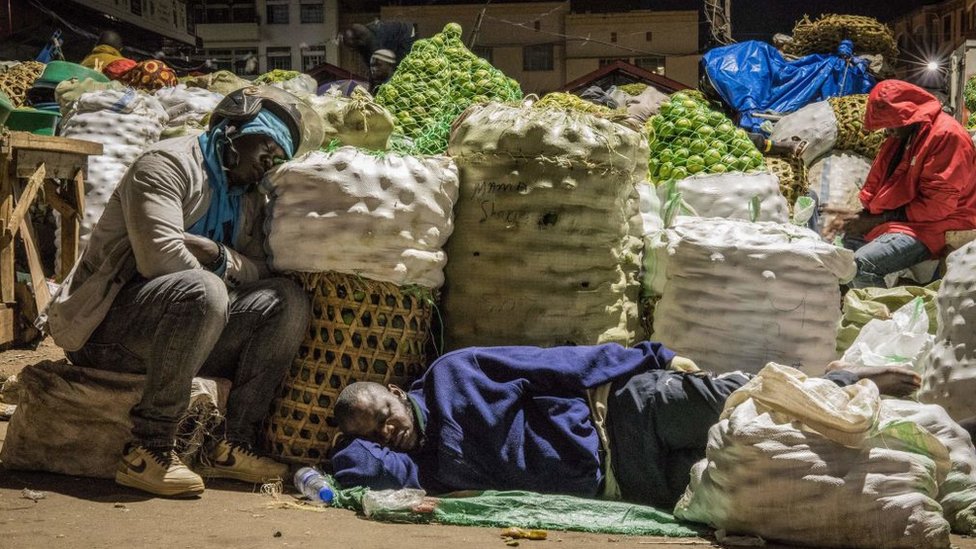 Торговцы спят рядом с предметами, которые будут продаваться на рынке после директивы президента Уганды Йовери Мусевени о том, что все продавцы должны спать на рынках в течение 14 дней, чтобы ограничить распространение коронавируса COVID-19 на рынке Накасеро в Кампале, Уганда, 7 апреля. , 2020