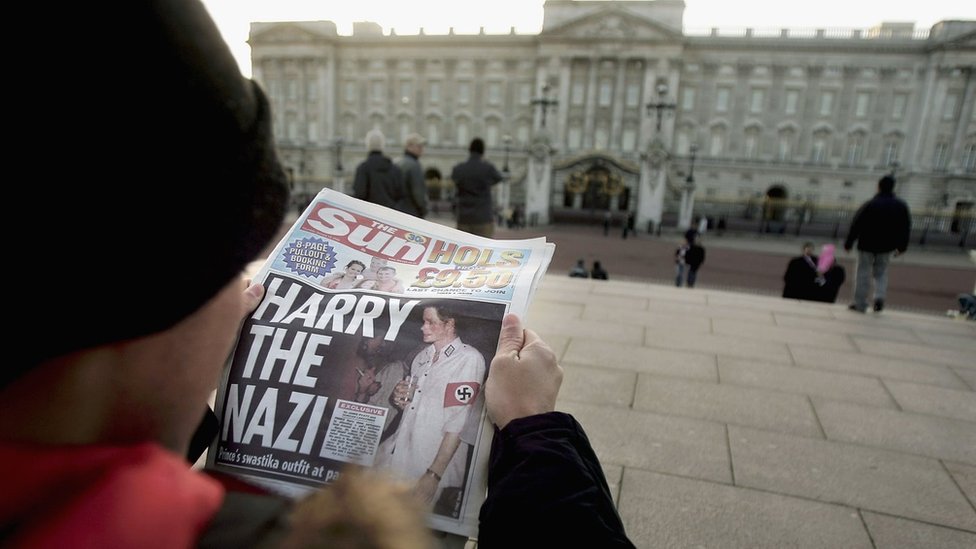 Женщина с газетой Sun, с Гарри в костюме нациста на первой полосе