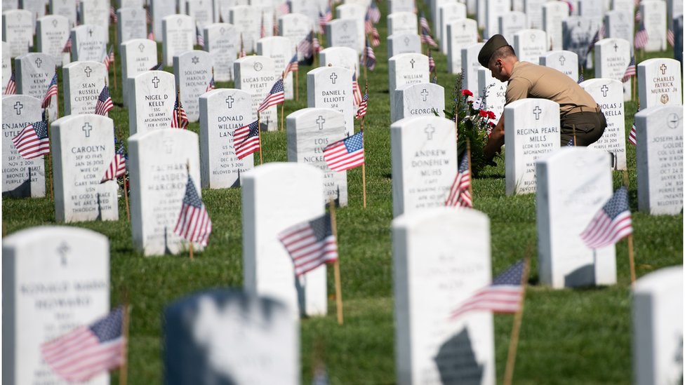 جندي يضع إكليلا من الزهور في مقابر الجنود الأمريكيين الذين قتلوا في العراق وأفغانستان