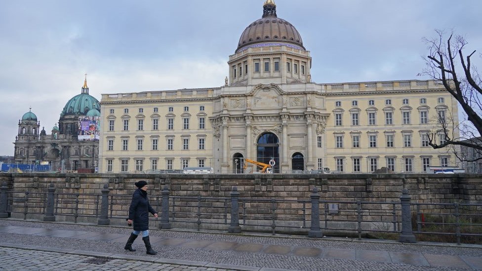 Женщина проходит мимо Берлинского дворца перед открытием форума Гумбольдта, транслируемого в цифровом формате, во время второй волны пандемии коронавируса