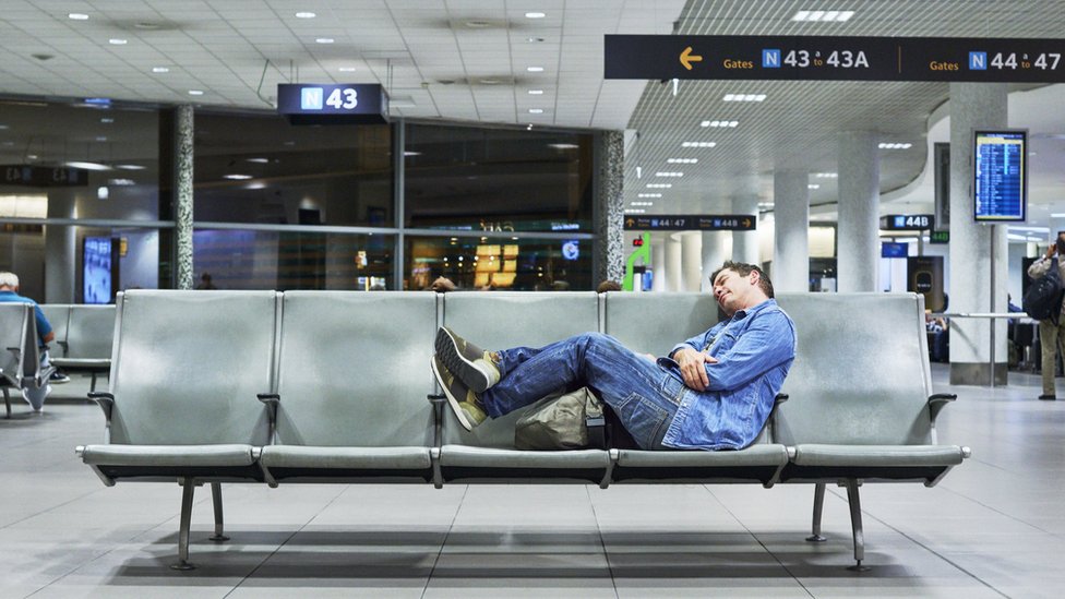 Un hombre dormido en un aeropuerto
