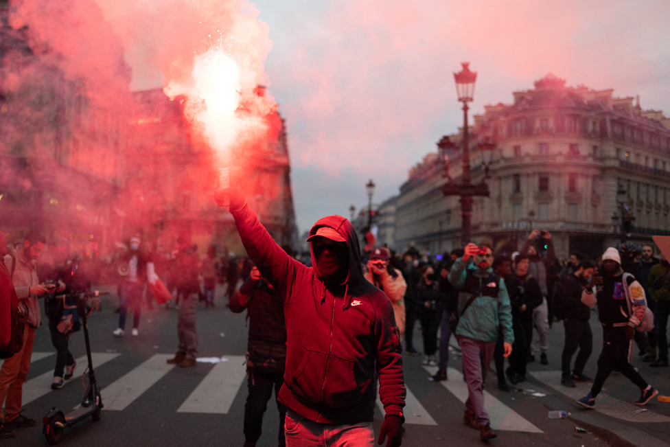 Protester hold a flare on the place de l opera during a demonstration, a week after the government pushed a pensions reform through parliament without a vote, using the article 49.3 of the constitution, in Paris on March 23, 2023.