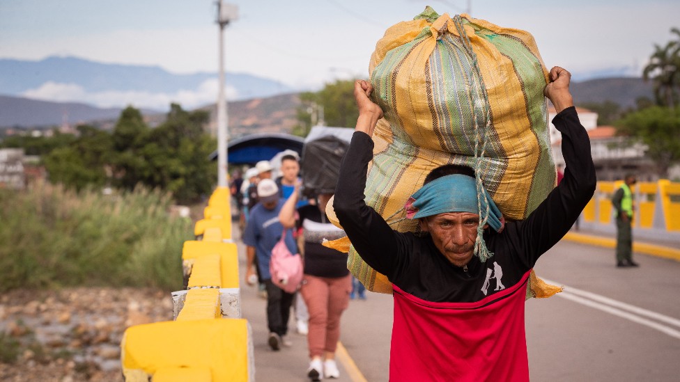 Varios hombres cargando mercancias en la frontera