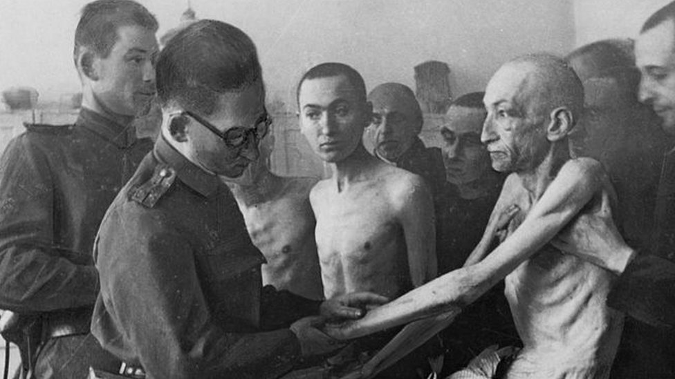 Um médico militar soviético examina un sobrevivente