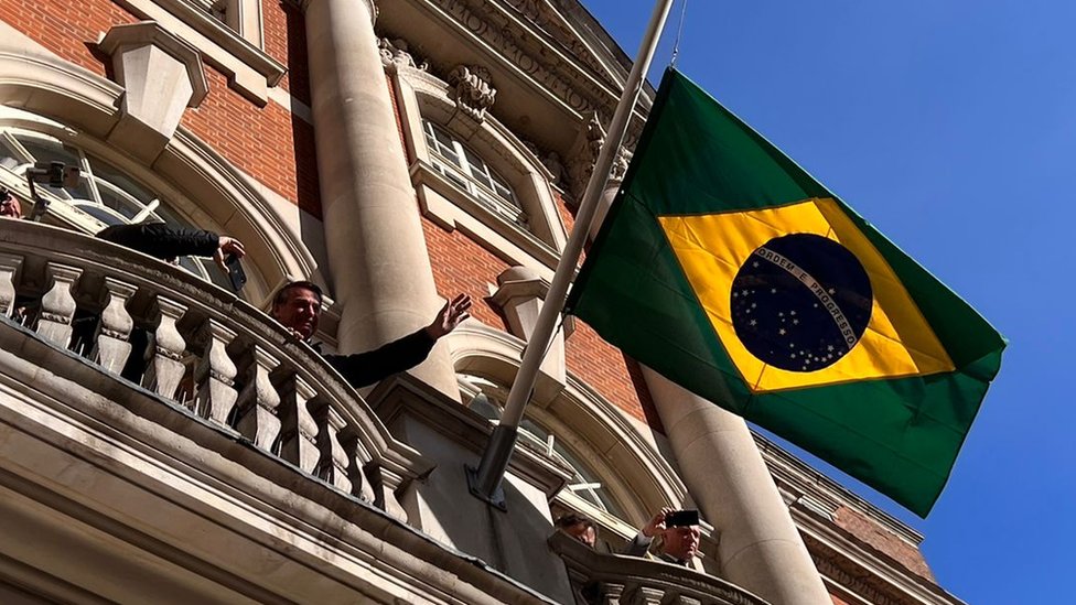 Com bandeira a meio mastro, Bolsonaro discursa a apoiadores na sacada da residência do embaixador em Londres