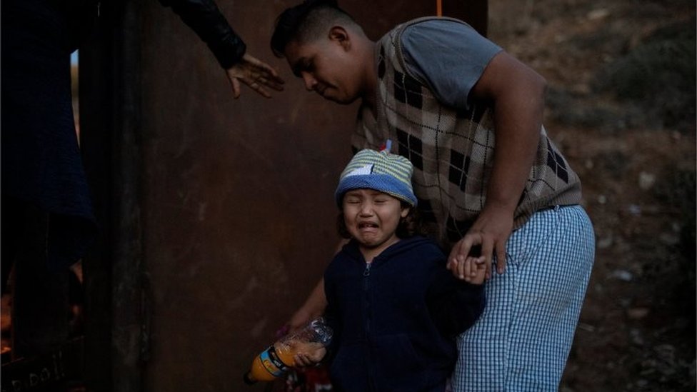 Una niña se dispone a saltar la vaya ayudada por sus familiares