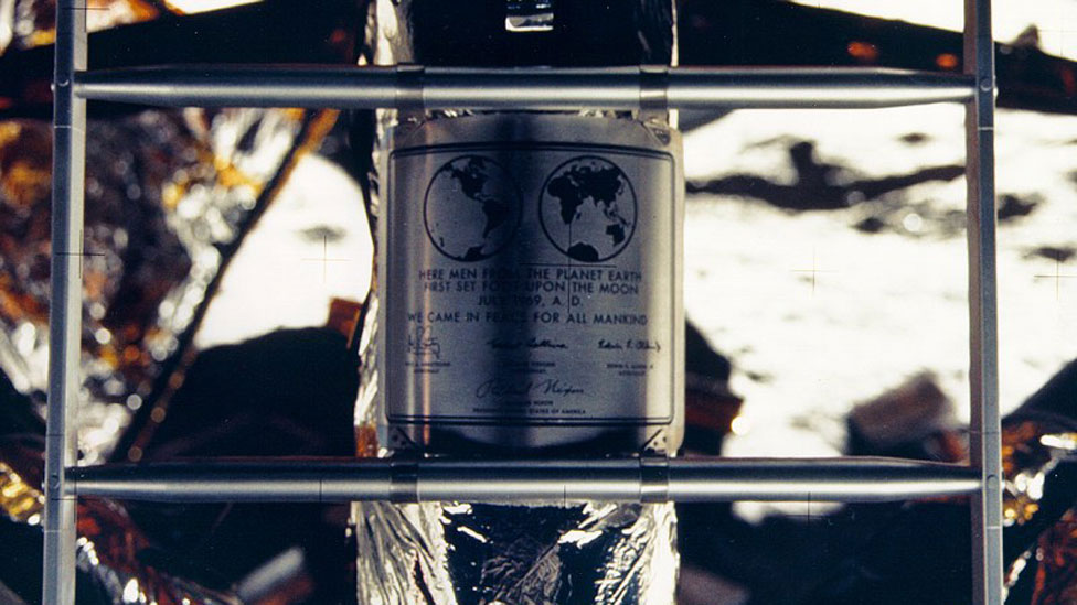 Placa dejada por el Apolo 11 en la Luna con el texto: "Vinimos en paz de nombre de toda la humanidad"