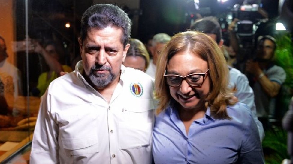 Венесуэльский оппозиционер Эдгар Самбрано (слева) гуляет со своей женой Собеллой Мехиас после освобождения из тюрьмы 17 сентября 2019 года в Каракасе.