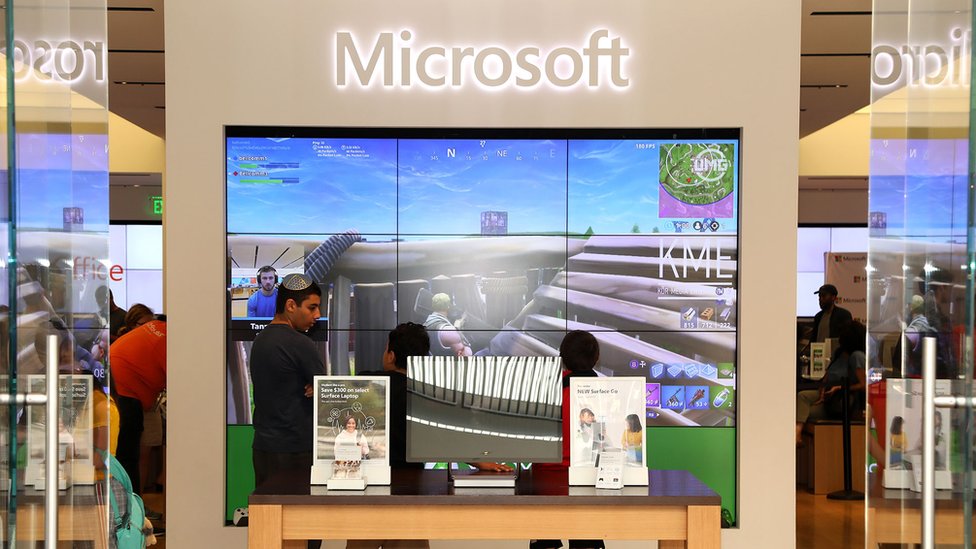Гигантский логотип Microsoft над экраном стены показывает, что в Fortnite играет стример - внутри фирменного магазина Microsoft