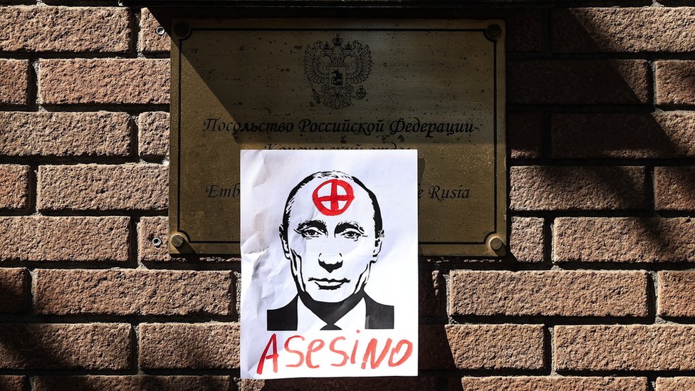 Un cartel con la cara de Vladimir Putin y la palabra "Asesino" pegado en la entrada de la embajada de Rusia, en Santiago Chile