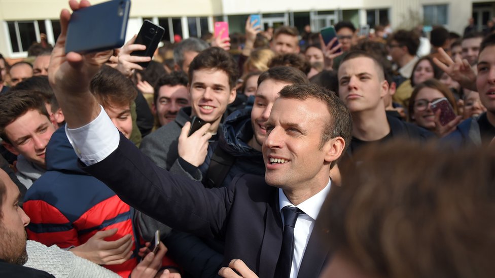 El presidente francés Emmanuel Macron tomándose un selfie.