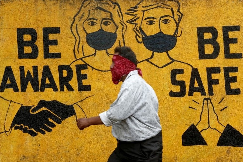 Мужчина проходит мимо граффити на фоне распространения коронавирусной болезни (COVID-19) в Мумбаи, Индия, 2 ноября 2020 года.