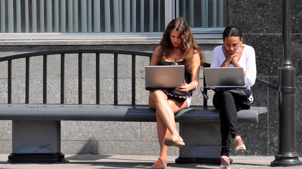 laptoplarıyla oturan iki kadın.