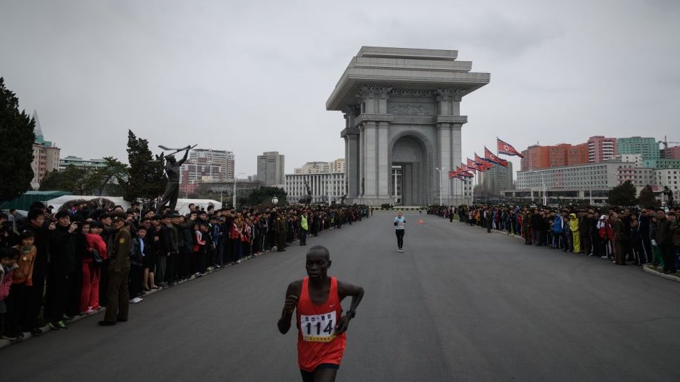 Ближе к концу гонки участники пробегают мимо Триумфальной арки Пхеньяна