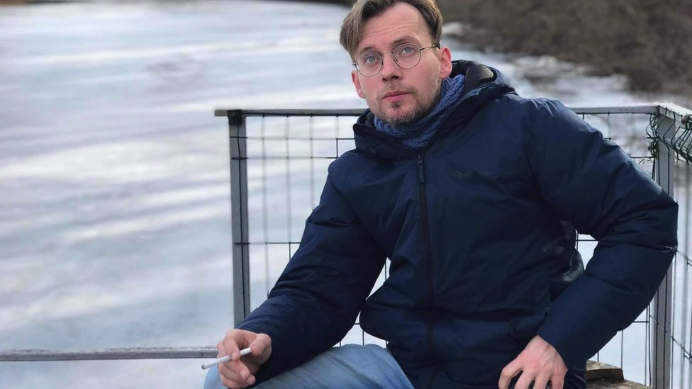 Ilya Barabanov sitting, smoking a cigarette