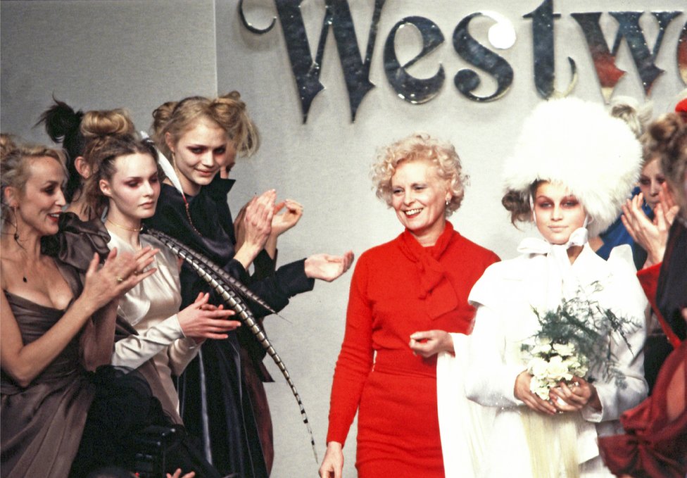 Vivienne Westwood y la modelo Laetitia Casta caminan por la pasarela durante el desfile de moda Otoño/Invierno 1996-1997 como parte de la Semana de la Moda de París el 7 de marzo de 1996.