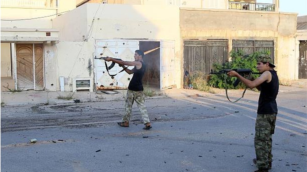 مقاتلان يتبعان حكومة الوفاق الوطني يطلقان النار على مواقع لتنظيم الدولة الإسلامية في سرت في صورة تعود إلى أغسطس/ آب 2016