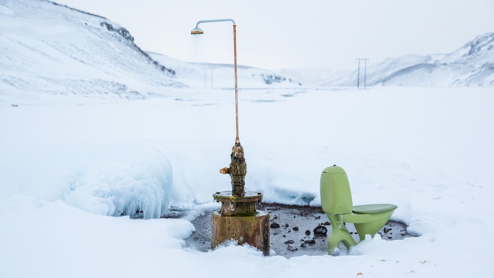 En una fuente termal en Islandia, alguien instaló un cabezal de ducha en esta tubería, que todavía rocía agua caliente durante todo el año. Por supuesto, cada ducha necesita un inodoro para acompañarlo. Una visión extraña en los áridos campos nevados de Islandia y se sabe muy poco de dónde provienen los artículos. Ducha en medio de la nieve