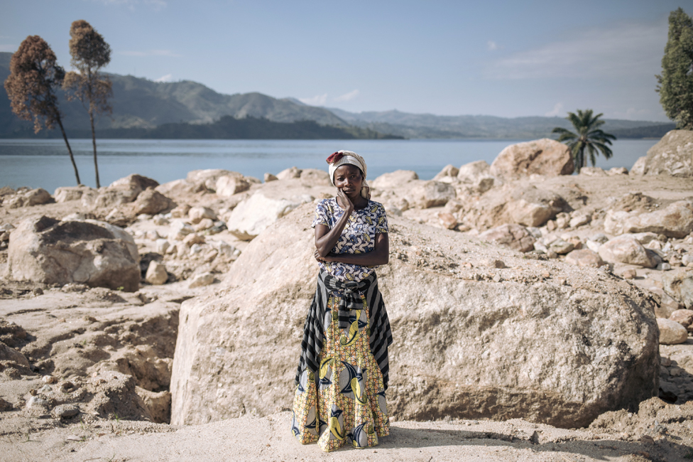 يوم الجمعة، سيدة تقف أمام أنقاض منزلها الذي انهار جراء انزلاق أرضي، بسبب فيضانات قرب بحيرة كيفو في جمهورية الكونغو الديمقراطية