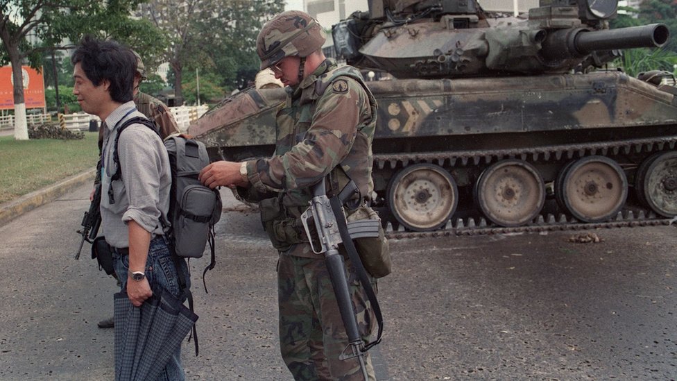 Американский солдат обыскивает сумку папского курьера во время операции «Правое дело» у посольства Ватикана в Панама-Сити 28 декабря 1989 года.