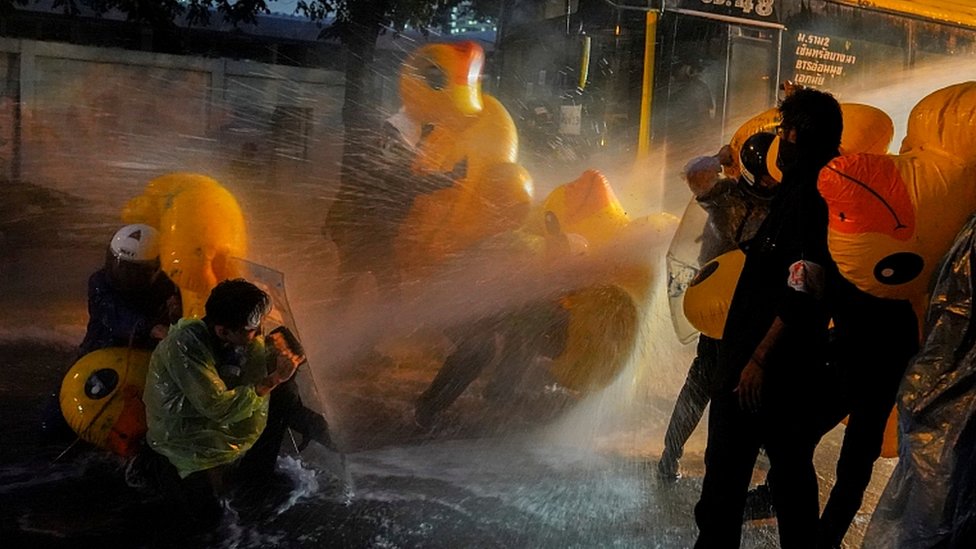 Demonstrators use inflatable rubber ducks as shields to protect themselves from water cannons during an anti-government protest in Bangkok, Thailand, November 17, 2020