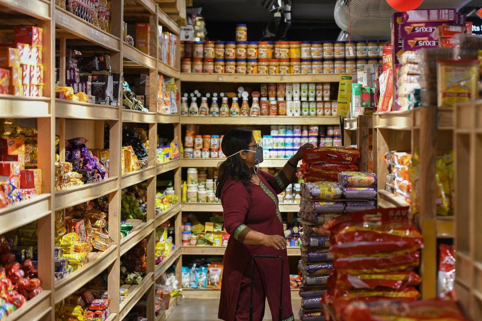 Люди покупают продукты в супермаркете в Индии.