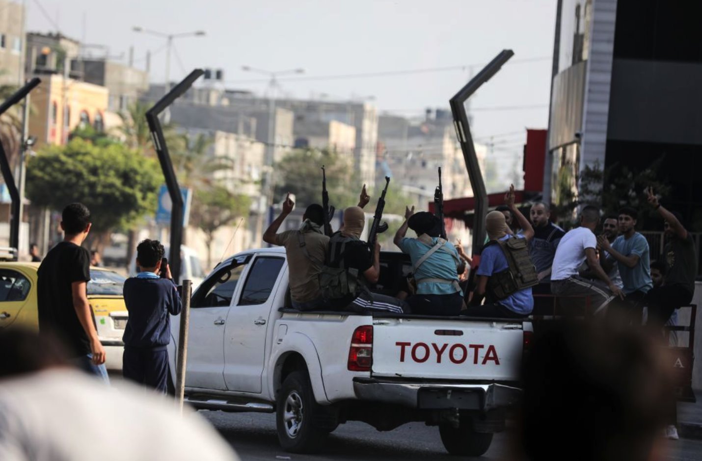 加沙北部埃雷茲過景點附近一群朝天舉槍的哈馬斯戰鬥人員乘坐皮卡返回加沙（7/10/2023）