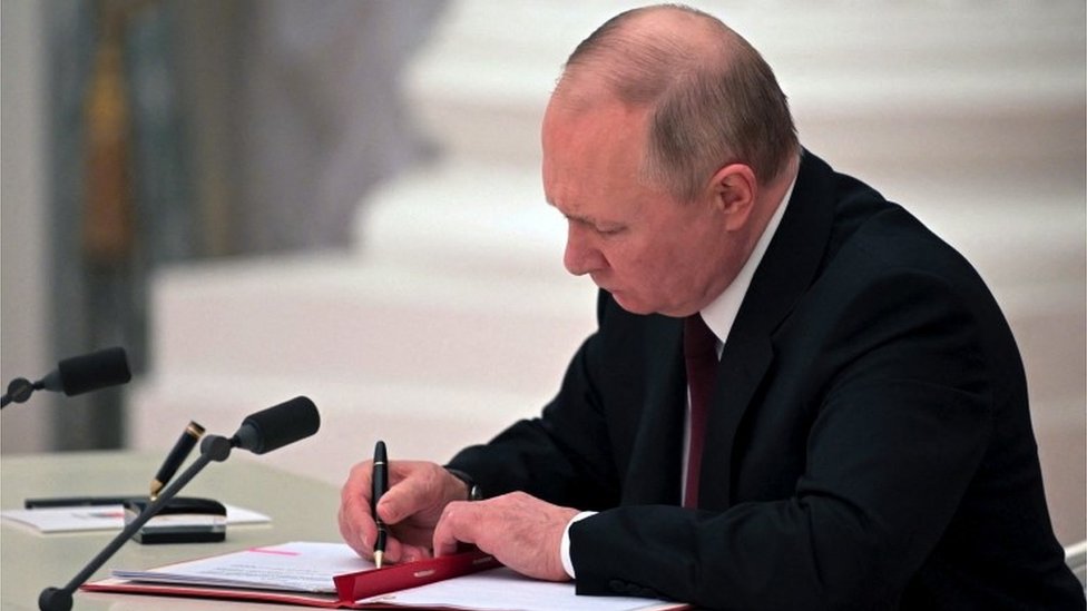 Putin assinando documento