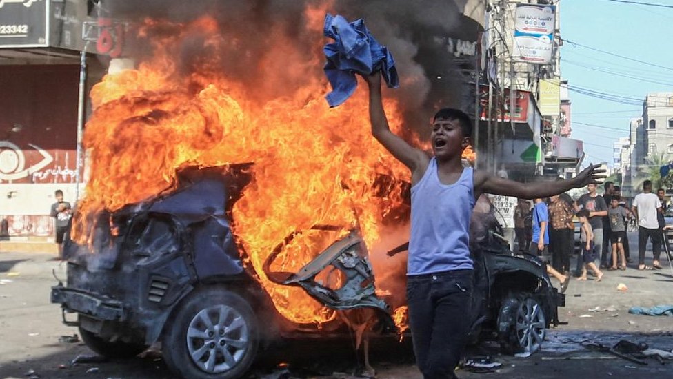 Palestinski dečak ispred zapaljenog izraelskog automobila koji su zaplenili militanti i odveli u Gazu