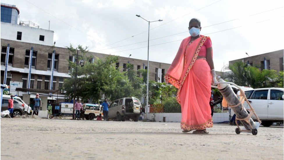 Женщина несет кислородный баллон в медицинском колледже и больнице Наланды 22 июля 2020 года в Патне, Индия