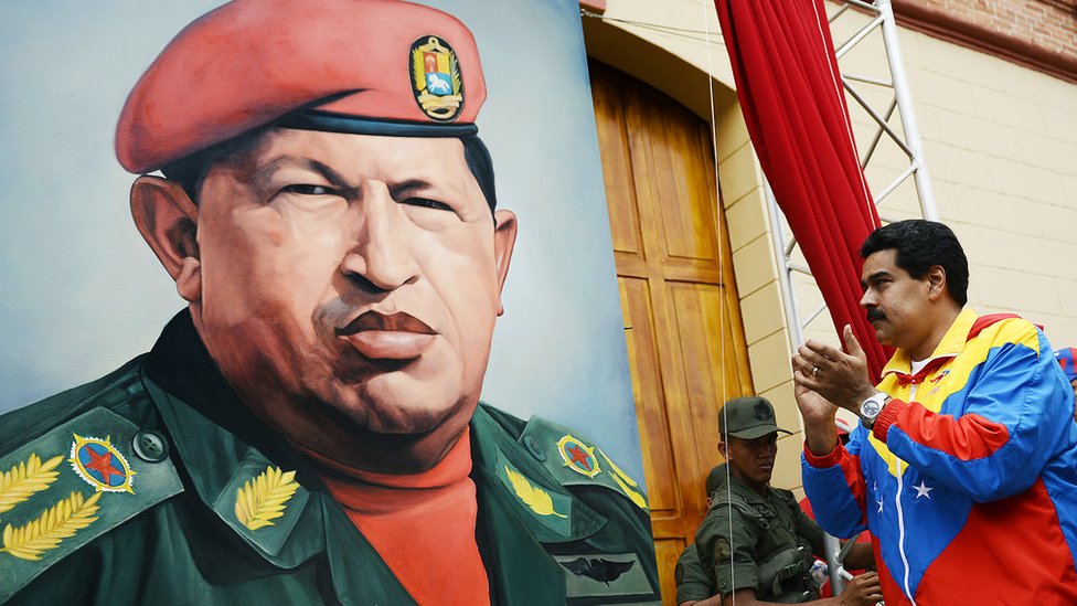 Nicolás Maduro ante un cartel de Hugo Chávez