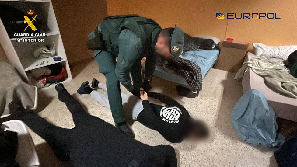 A member of the Civil Guard arrests people allegedly involved in illegal tobacco production