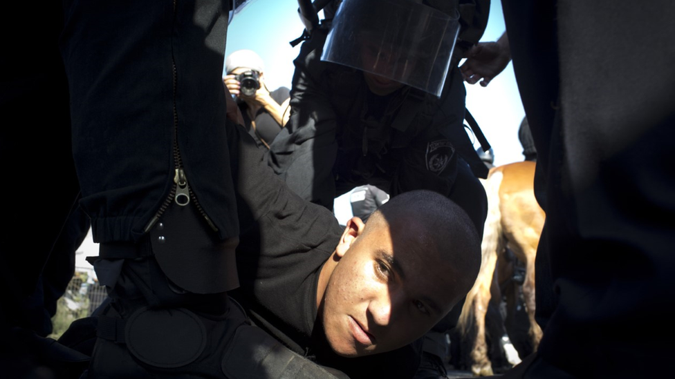 Israeli police arrest a protester as Israel Arabs protest against the Israeli government's Prawer Plan, on road 65 on August 1, 2013 near Arara, Israel.
