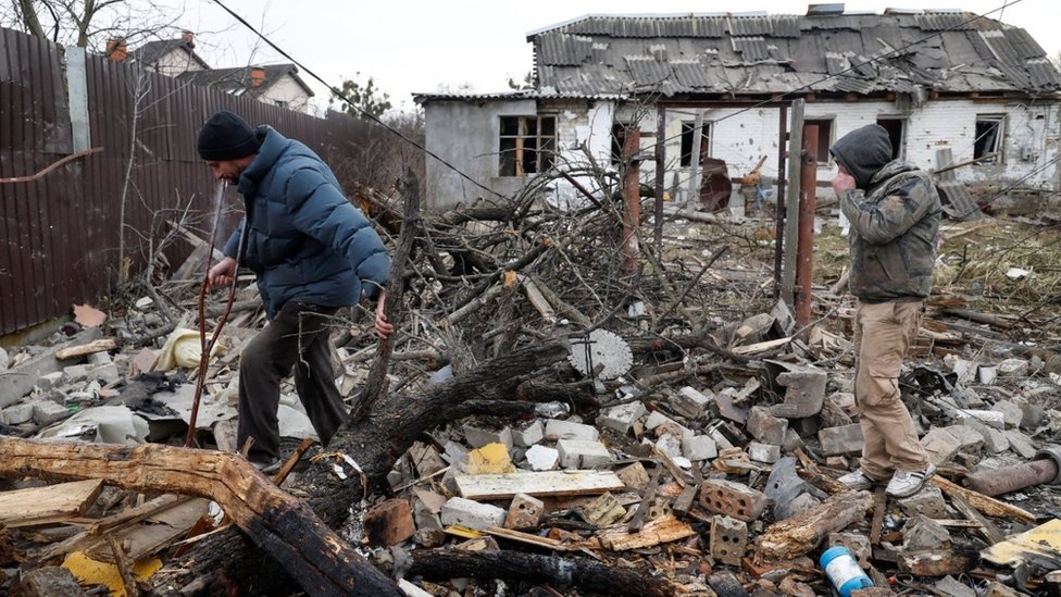 سكان أوكرانيون يسيرون في موقع منازل سكنية دُمرت خلال ضربة صاروخية روسية على مدينة كييف